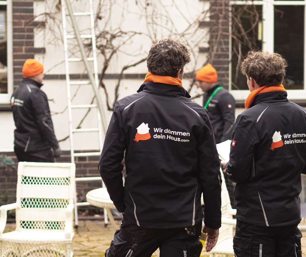WDDH-Handwerker in Firmenjacken vor einem Haus bei der Dämmung